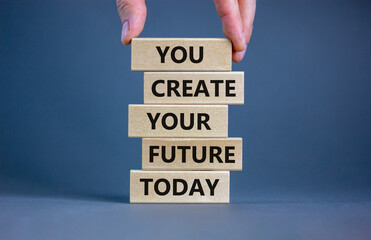 You create your future today symbol. Concept words 'You create your future today' on wooden blocks on a beautiful grey background. Businessman hand. Business, motivational and create future concept.