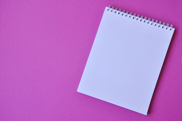 Blanc spiral school notepad. Top view notepad on color pink background