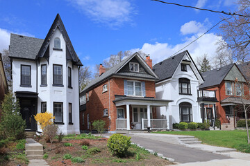 Street with row of narrow old brick detached houses with gables - 428678785