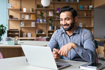 Happy smiling ethnical indian businessman having online virtual meeting call on laptop looking at...