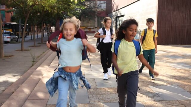Portrait of preteen schoolchildren with rucksacks outdoors on their way to college in warm autumn day. Back to school concept
