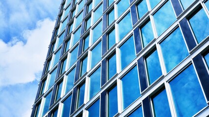 Abstract closeup of the glass-clad facade of a modern building covered in reflective plate glass. Architecture abstract background. Glass wall and facade detail. Velvia graphic filter.