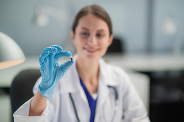 The doctor prescribes the medicine and presents the patient with its antiviral properties. A hand in a medical glove in the foreground