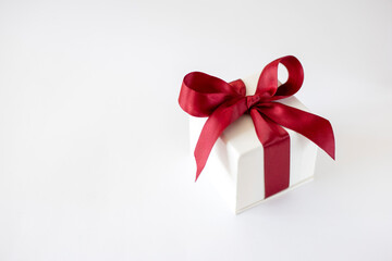 White box with a red bow on a white background. Gift concept