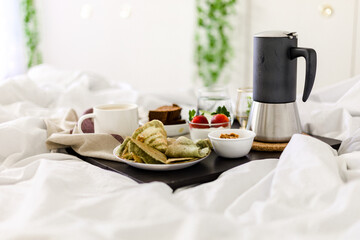 Fototapeta na wymiar Breakfast on bed with mocha pot - Lentil crepes, strawberry & yogurt