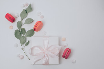 Beautiful gift boxes, eucalyptus leaves and sweets on white toned background. Flat lay, top view, copy space