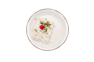 Traditional Turkish milky Ramadan Dessert named Gullac with sugar, powder of pistachio, milk and gullac sheets (rice wafer or rice paper sheets) on vintage metal plate isolated on white background.