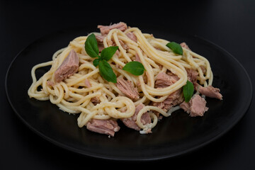 pasta with tuna and basil leaves,  isolated on black, side view