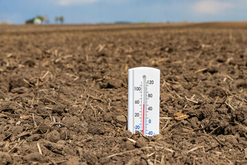 Thermometer is soil of farm field. Soil temperature, planting season and farming weather forecast...