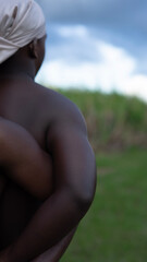 isolated close-up of young African men locking shoulders in open field