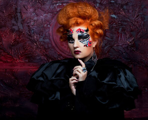 Gothic witch. Dark woman. Red-haired woman with bright make up.