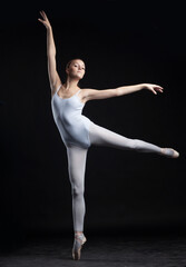 young gymnastic ballet dancer dancing in white body isolated on black background