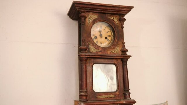 Broken antique mechanical wall clock that once showed the hour in room. Time