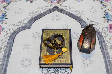 Holy Quran book, rosary and arabian lantern on praying mat. Islamic Ramadan concept