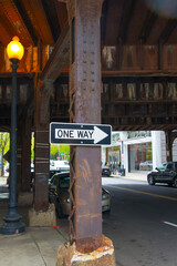One Way sign on a rusty bridge support