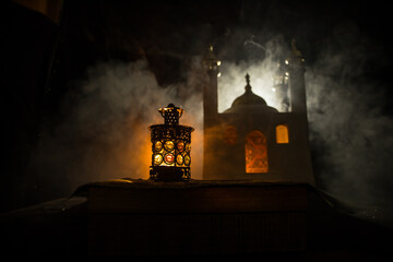 Fototapeta premium Ornamental Arabic lantern with burning candle glowing at night. Festive greeting card, invitation for Muslim holy month Ramadan Kareem.