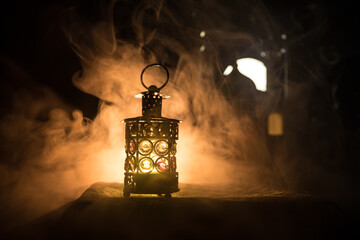 Ornamental Arabic lantern with burning candle glowing at night. Festive greeting card, invitation for Muslim holy month Ramadan Kareem.
