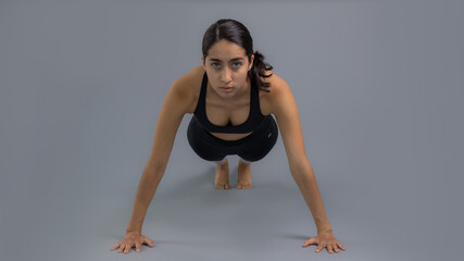 Joven mujer latina mexicana atleta instructora entrenando yoga dando calentamiento y estiramiento...