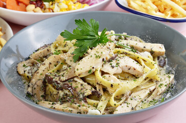 Wide noodles with chicken, truffle mushroom, butter, and cream sauce in plate