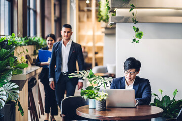 Group of professional multiethnic teamwork business discussing meeting strategy sharing idea with new startup project.Creative business people working with laptop computer in green plant terrace