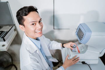a male doctor operating an eye computer in a room at an eye clinic