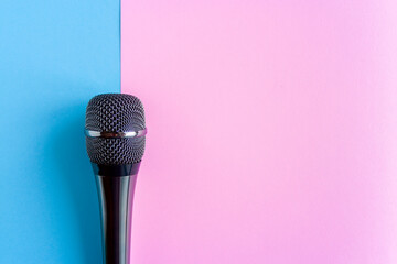 Microphone on a colorful pink and blue geometric background close up. Singing, writing music,...