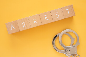 逮捕｜「ARREST」と書かれた積み木とおもちゃの手錠