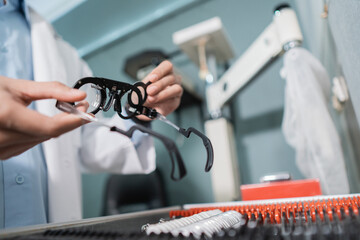 an eye doctor's hand is taking a test glasses lens gauge in a box containing a set of lenses in an eye clinic