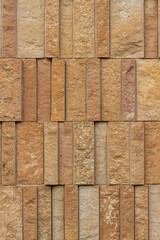 This image shows a rough texture stone wall background with attractive narrow vertical kasota limestone blocks in varying widths, and shades of brown and beige