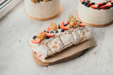 Dessert Anna Pavlova with berries. Meringue roll with wild berries. Homemade pastry workshop with desserts