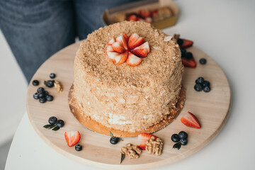 Delicious honey cake with berries. Home confectionery factory. Ready-made birthday cake