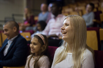 Obraz premium caucasian woman sitting at funny perfomance in theatrical auditorium