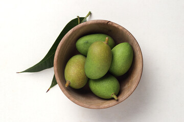 Tender mango on a white base for Indian style mango pickle.