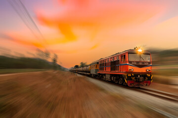 Fast speed motion cargo train on railway with twilight sun sky background.