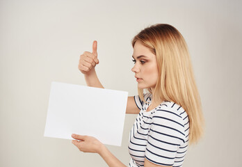 Woman gestures with her hands on a beige background of emotions and a white sheet of paper