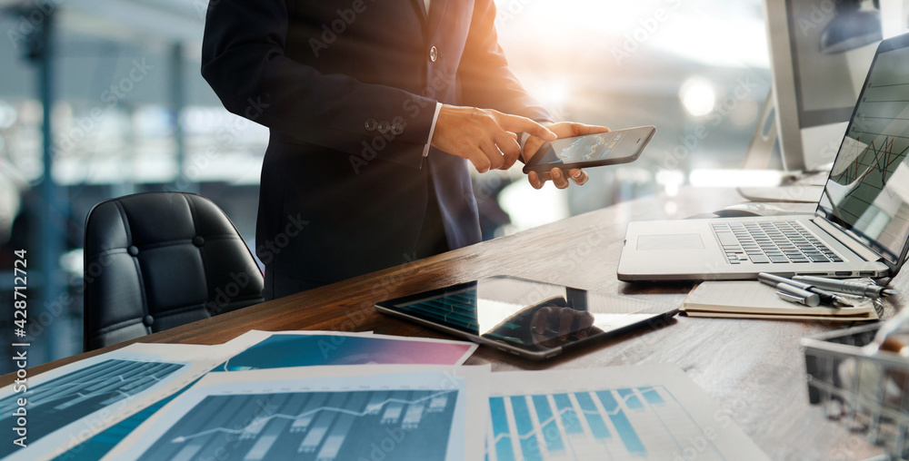 Poster Businessman using mobile smartphone and laptop analyzing sales data and economic growth graph chart. Digital marketing. Strategy and planning.