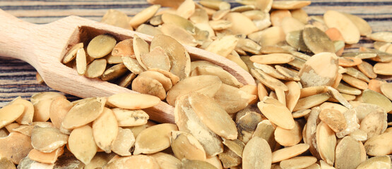Heap of pumpkin with spoon on wooden board. Healthy food containing dietary fiber