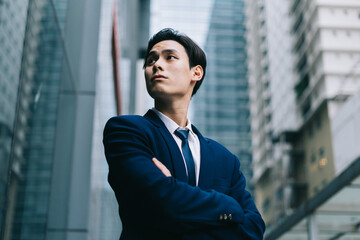 Image of Young asian businessman with glass building background