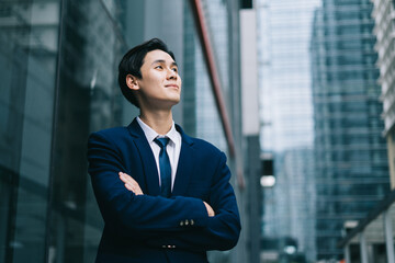 Image of Young asian businessman with glass building background