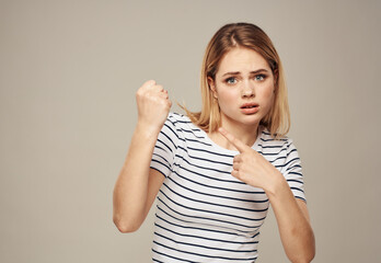 Fototapeta na wymiar Upset woman emotions blonde beige striped t-shirt background