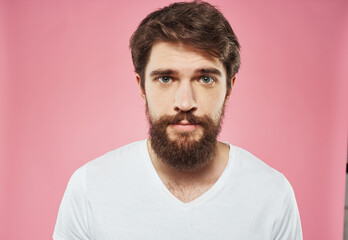 Fototapeta premium Man with a beard on a pink background sad face emotions model