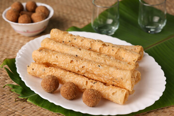 Indian fried snack Kuzhalappam Kerala fried snacks food on banana leaf background. Kerala tea time food fried in coconut oil. Top view of South Indian snacks.	