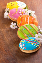 gingerbread cookie in the form of color eggs on dark wooden background. Happy Easter card.