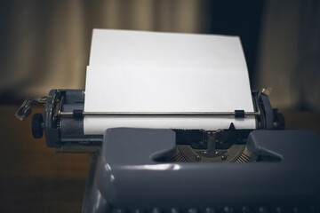 old typewriter with white paper sheet. Space for your text