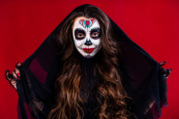 1st and 2nd november celebration of day of the dead in mexico concept woman with grimm skull face and black cloth with veil on the head in studio
