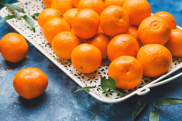 Tray with sweet tangerines on color background, closeup