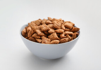 Bowl with tasty corn pillows on light background