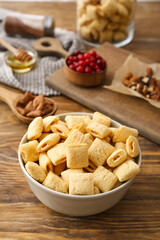 Bowl with tasty corn pillows on wooden background