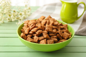 Bowl with tasty corn pillows on color wooden background