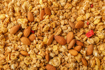 Tasty granola and almonds as background